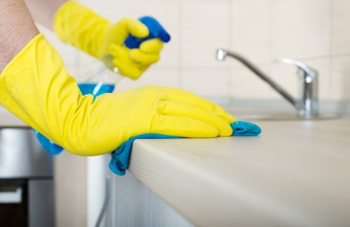 Local cleaner treating stains on a corner sofa in SE8