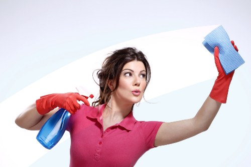 Local cleaner vacuuming a hallway in a SE8 flat during a scheduled visit